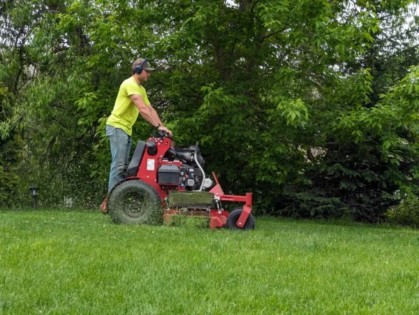 Leo using a riding lawnmower to cut grass on a Lino Lakes residential property